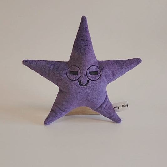 Video of purple plush starfish with embroidered face. Back side is light purple with raised dots.